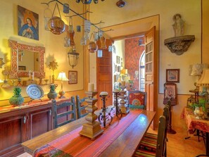 A dining area with a long wooden table, hanging lanterns, and a mirror above. - Casa Vida Gitana: Vibrant & Cozy Mexican Oasis (Mérida)