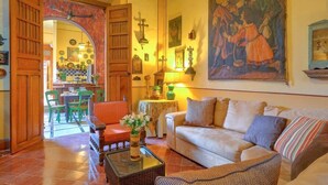 Un accogliente soggiorno con divano, poltrone, tavolino e zona pranzo con tavolo e sedie.