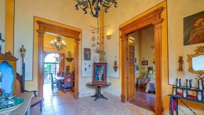 Un ambiente spazioso con un lampadario, porte in legno e una sala da pranzo.