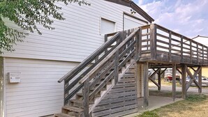 A wooden staircase leading to a covered area with a building in the background. - 8-BERTH CHALET WITH LARGE TERRACE (Gruissan)