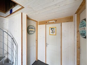 Ein Flur mit einer Treppe, einer Tür mit einem gerahmten Bild und einem Schild an der Wand.