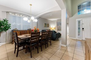 Un comedor con una mesa y sillas de madera, un candelabro y una planta en maceta.