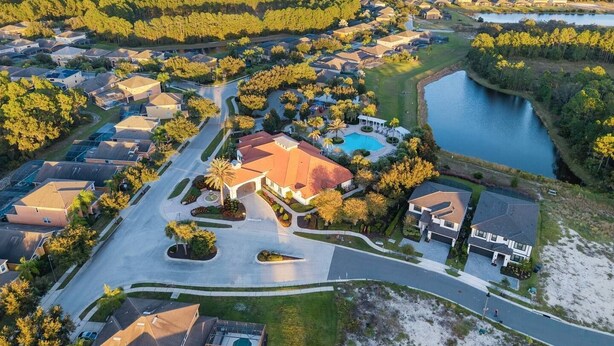 Un quartiere residenziale con case, una piscina e un lago.