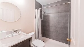 Ein Badezimmer mit Dusche, Toilette und Waschbecken.