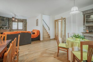 Un vaste espace de vie comprenant une table à manger, un canapé et un escalier menant à un autre niveau.