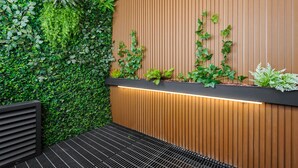 A modern interior with a vertical garden, wooden panel wall, and a black metal bench. - w* | Airy Loft w/Balcony in Parque Mexico (Ciudad de México)