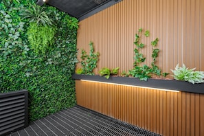 A modern interior with a vertical garden, wooden panel wall, and a black metal bench. - w* | Airy Loft w/Balcony in Parque Mexico (Ciudad de México)