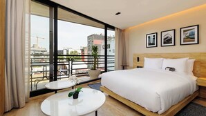 A hotel room with a large bed, a small table, a potted plant, and a balcony with a view of the city. - w* | Airy Loft w/Balcony in Parque Mexico (Ciudad de México)