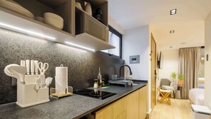 Eine moderne Küche mit einer Granit-Arbeitsplatte, einem eingebauten Backofen und einem Essbereich mit Stuhl und Tisch.