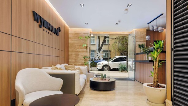 A modern reception area with a sofa, coffee table, and potted plant. - w* | Engaging Loft w/ Balcony in Parque Mexico (Ciudad de México)