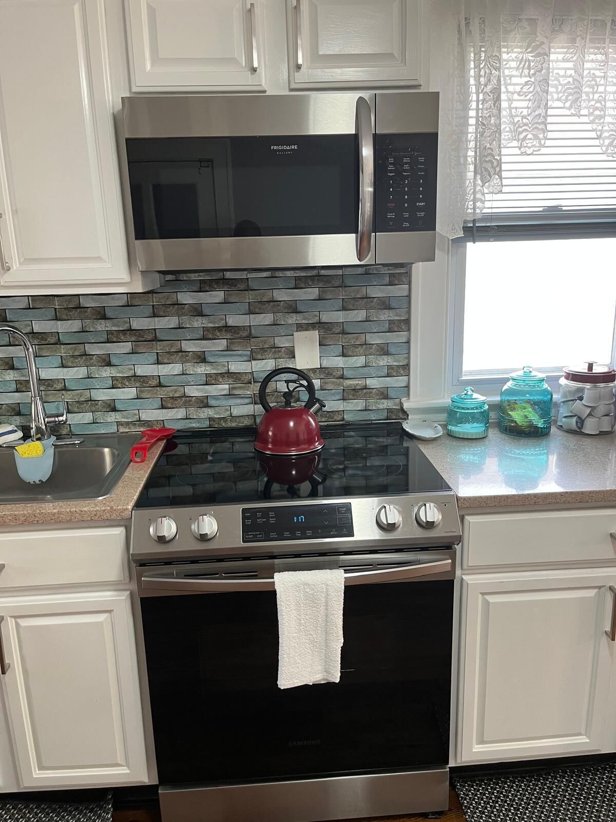 A kitchen with a stainless steel stove, oven, and microwave.