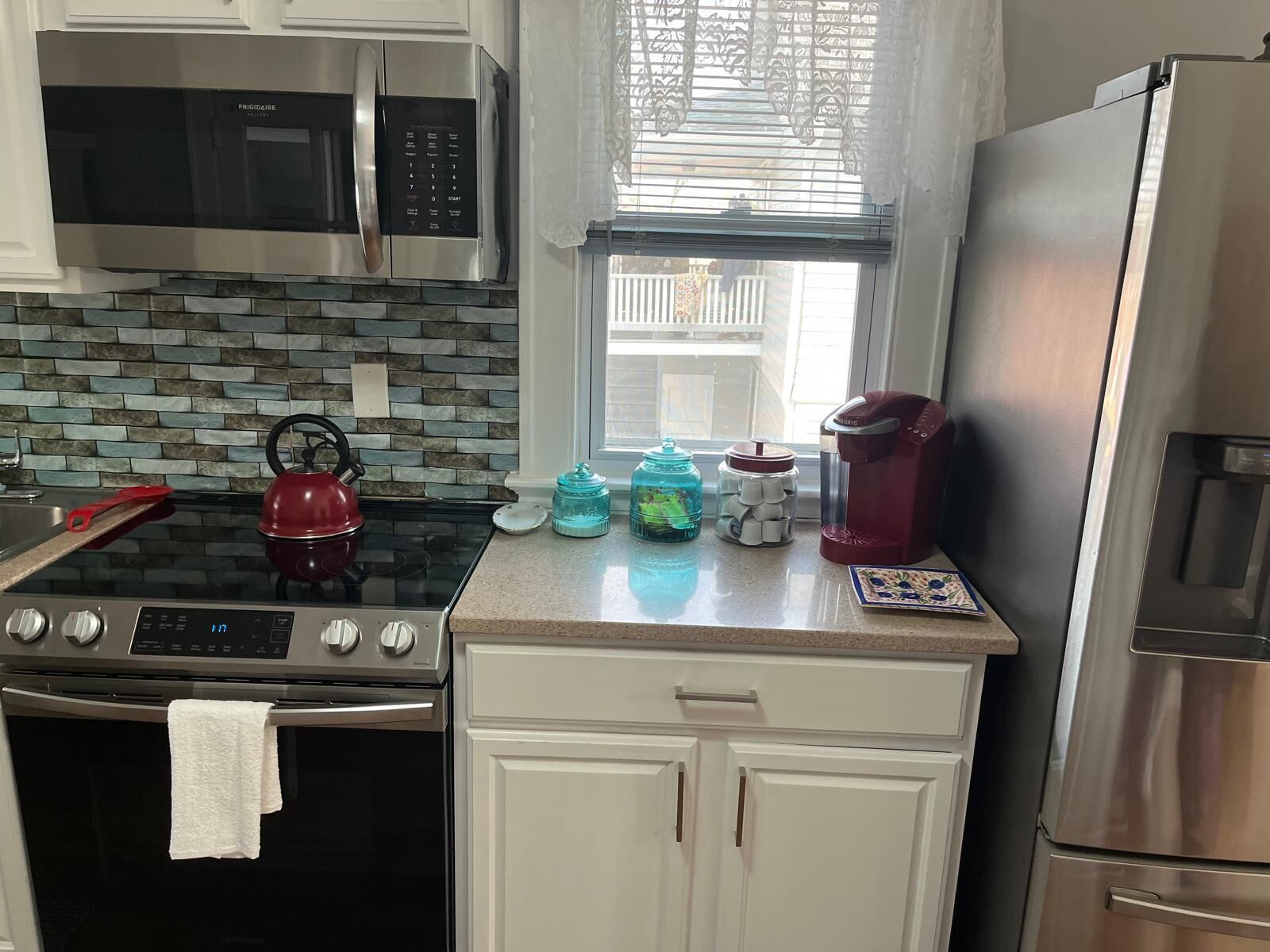 A kitchen with a microwave, stove, oven, and refrigerator.
