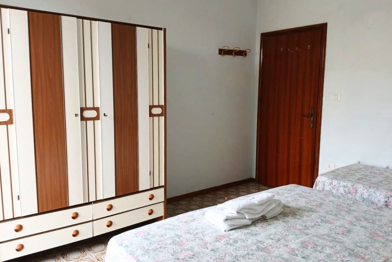 Une chambre à coucher avec un lit, une armoire et une porte.