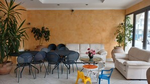 A room with a dining area, sofa, and chairs, featuring a large window and potted plants. - RG007 - Bellaria, comfortable three-room apartment 100 meters from the sea (Bellaria-Igea Marina)