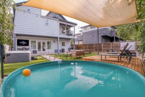 A backyard with a swimming pool, a hot tub, and a deck with outdoor furniture. - Luxury East Austin 6BR | Pool, Hot Tub, Roofdeck (Austin)