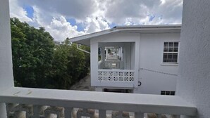 Un edificio blanco con un balcón y una ventana.