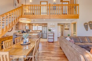 Eine geräumige Loft-Wohnung mit einer Holztreppe, einem Essbereich, einer Küche und einem Wohnzimmer.