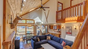 A spacious living area with a large sofa, a dining table, and a kitchen in the background. - Deer Park End Unit with Lake Access (Woodstock)