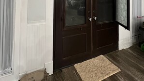 A dark wooden double door with glass panels, white wainscoting, and a beige rug on a wooden floor. - Fabulous 3-bedroom farmhouse in charming Weirsdale (Weirsdale)