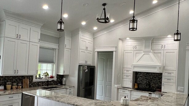 A spacious kitchen with white cabinetry, a large island with seating, and pendant lighting. - Fabulous 3-bedroom farmhouse in charming Weirsdale (Weirsdale)