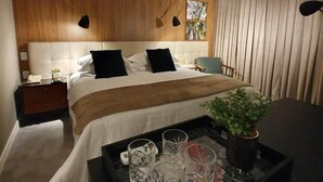 A modern hotel room with a bed, bedside table, lamp, curtains, and a tray with glasses and a plant. - #RD802 | Cyclinn Vila Olímpia (Vila Olímpia)