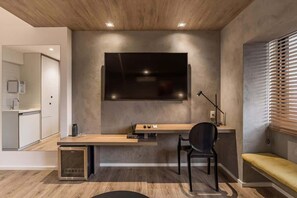 A modern kitchen with a built-in dishwasher, a wooden dining table, and a black chair. - #TR1501 | Cyclinn Faria Lima Itaim (Itaim Bibi)