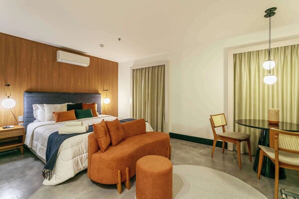 Une chambre d’hôtel moderne équipée d’un lit, d’un canapé, d’une table à manger et d’une chaise.