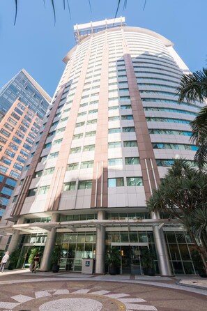 A high-rise hotel with a curved facade, large windows, and a modern entrance with a glass canopy. - #RD513 | Cyclinn Vila Olímpia (Vila Olímpia)