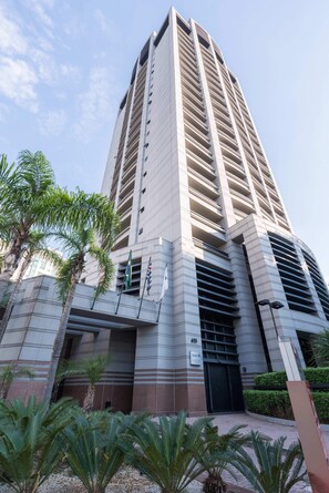 A tall building with a modern design, featuring a large entrance and multiple balconies. - #RB211 | Cyclinn Cidade Jardim - Itaim (Itaim Bibi)