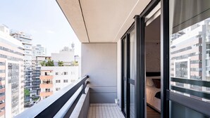 A balcony with a tiled floor, a black railing, and a view of adjacent buildings. - #RB1107 | Cyclinn Cidade Jardim Itaim (Itaim Bibi)