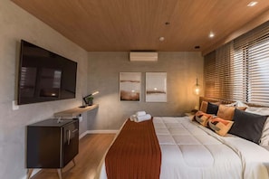 A modern bedroom with a bed, a TV, a bedside table, and a window with blinds. - #TR1209 | Cyclinn Faria Lima Itaim (Itaim Bibi)