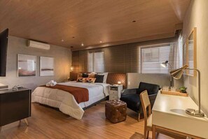 A modern bedroom with a bed, desk, chair, and a small table with a lamp. - #TR1209 | Cyclinn Faria Lima Itaim (Itaim Bibi)