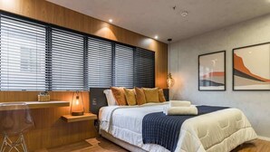 A modern bedroom with a bed, bedside table, lamp, and artwork on the wall. - #TR1204 | Cyclinn Faria Lima Itaim (Itaim Bibi)