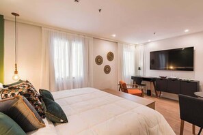 A modern hotel room with a large bed, a desk, a chair, a TV, and decorative wall art. - #TR809 | Cyclinn Faria Lima Itaim (Itaim Bibi)