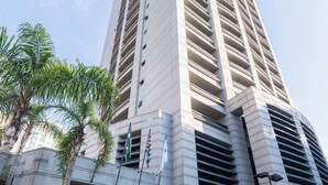 Un immeuble moderne et imposant, doté d’une façade symétrique, de nombreux balcons et d’une entrée sécurisée par un portail.