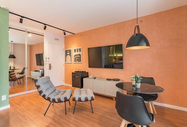 Un salon moderne comprenant un canapé, une table à manger et un coin cuisine.