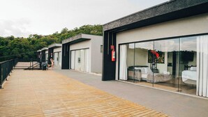 A modern hotel with a wooden deck, large sliding glass doors, and a fire extinguisher mounted on the wall.