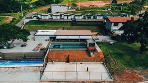 A modern building with multiple units, a swimming pool, and a wooden deck area.