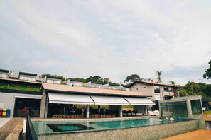 Una piscina al aire libre, sillones reclinables de piscina
