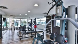 A gym with cardio machines, weightlifting equipment, and a mirrored wall. - #BE1902 | Cyclinn Vila Olímpia Berrini (Berrini)