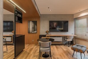 Eine moderne Küche mit einem eingebauten Kühlschrank, ein Essbereich mit einem runden Tisch und Stühlen sowie ein großes, abstraktes Gemälde an der Wand.