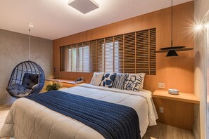 A modern bedroom with a large bed, a hanging chair, wooden slats on the window, and a bedside table with a lamp. - #BC407 | Cyclinn Bela Cintra Jardins (Bela Cintra)