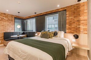 A modern bedroom with a bed, a seating area, and large windows. - #BE305 | Cyclinn Vila Olímpia Berrini (Berrini)