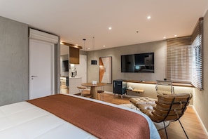 A modern bedroom with a large bed, a desk, a chair, and a TV. - #TR706 | Cyclinn Faria Lima Itaim (Itaim Bibi)