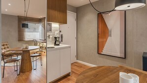 Una cucina moderna con una macchina da caffè, mobili in legno e un'area pranzo con un tavolo rotondo e sedie.