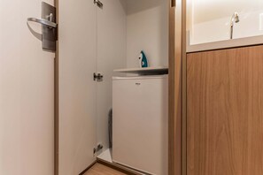 A bathroom with a shower, a sink, and a compact storage unit. - #BE601 | Cyclinn Vila Olímpia Berrini (Berrini)