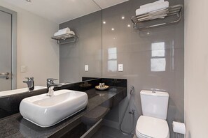 A modern bathroom with a large mirror, a white sink, a toilet, and a shower. - #IN1704 | Cyclinn Jesuíno Arruda Itaim (Itaim Bibi)
