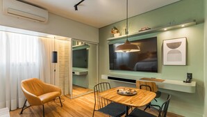 A modern interior with a wooden dining table, a sofa, and a TV mounted on the wall. - Cyclinn a 400m do WTC Berrini Vila Olímpia #WB1711 (Berrini)
