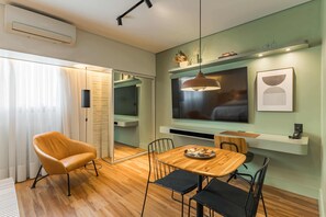 Ein modernes Interieur mit einem Holztisch, einer Couch und einem an der Wand montierten Fernseher.