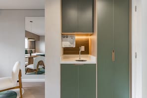 A compact kitchenette with a built-in coffee maker, a small sink, and a wooden backsplash. - Cyclinn a 400m do WTC Berrini Vila Olímpia #WB809 (Berrini)